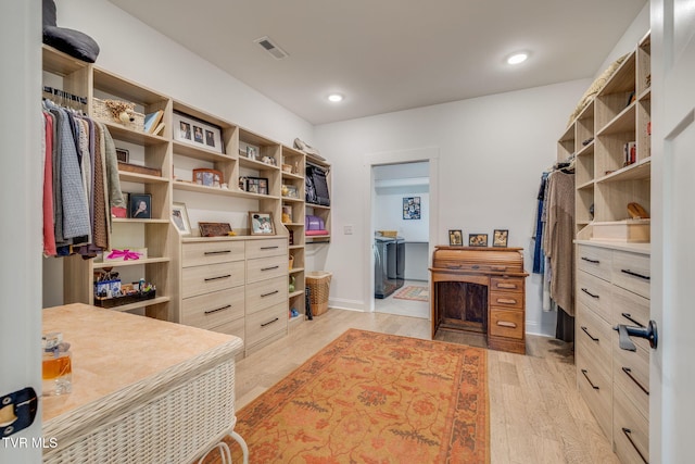 walk in closet featuring light wood-style flooring and washer / clothes dryer