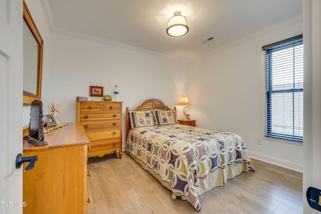 bedroom with light wood finished floors, ornamental molding, and baseboards