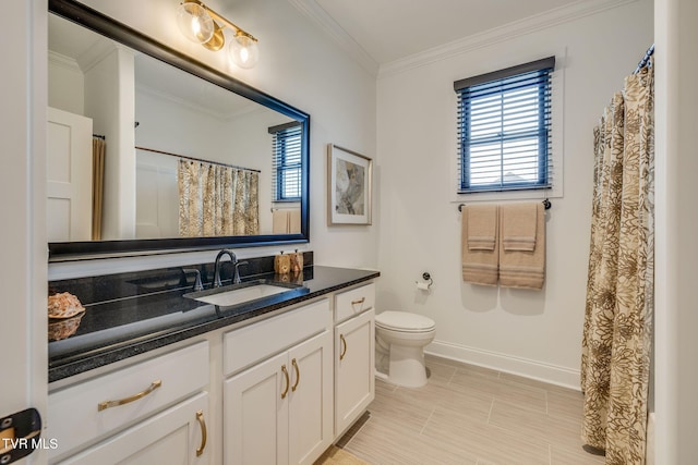 full bath with baseboards, healthy amount of natural light, crown molding, vanity, and toilet