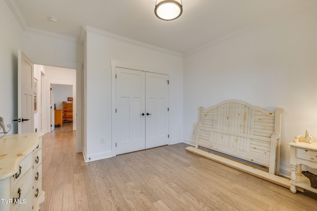 unfurnished bedroom featuring ornamental molding, light wood-style floors, a closet, and baseboards