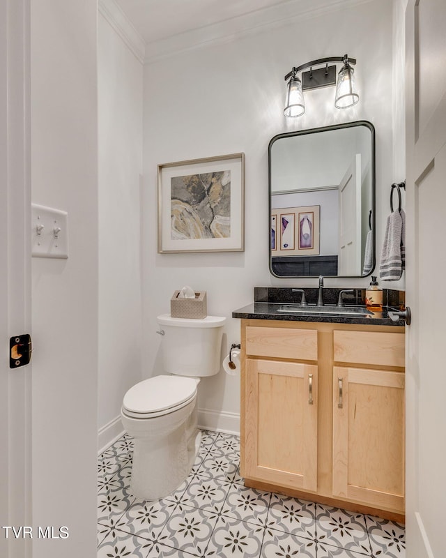 half bathroom with crown molding, baseboards, toilet, and vanity