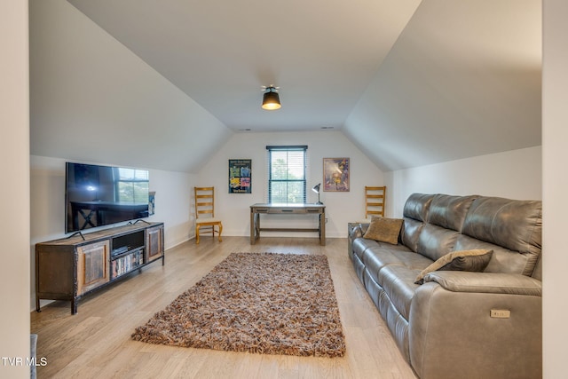 living area with wood finished floors, lofted ceiling, and baseboards