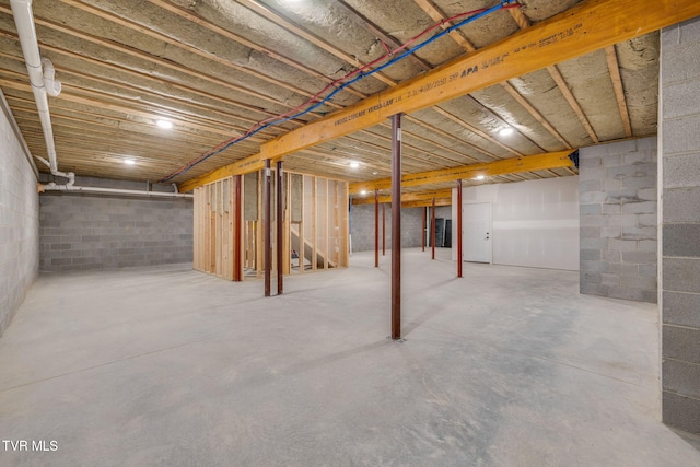 unfinished below grade area featuring stairs and concrete block wall