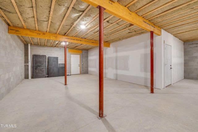 unfinished basement featuring concrete block wall