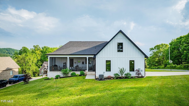 modern farmhouse style home with board and batten siding, a front lawn, and central AC