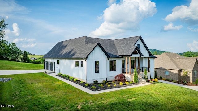 modern inspired farmhouse featuring a front lawn, roof with shingles, and board and batten siding