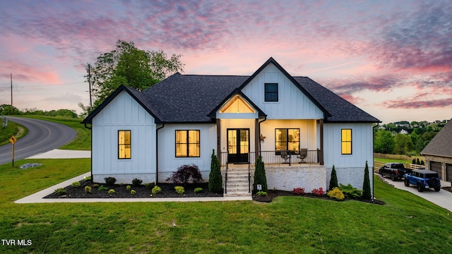 modern farmhouse style home with french doors, a front yard, and a shingled roof