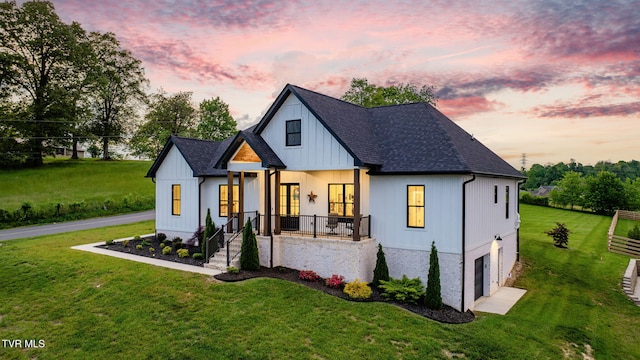 modern inspired farmhouse featuring an attached garage, roof with shingles, and a front yard