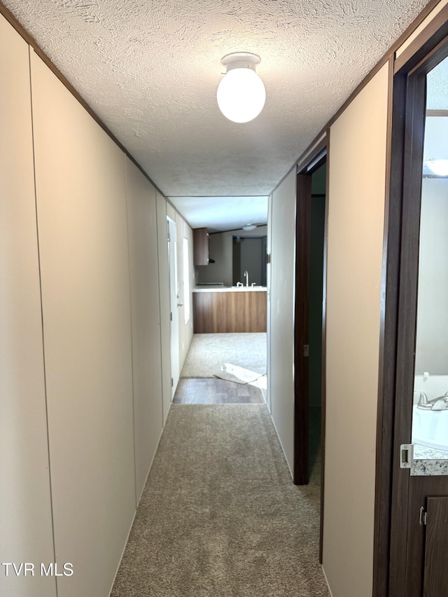 236 Redwood Dr, Raven, VA 24639 - hallway with a textured ceiling, a sink, and carpet floors