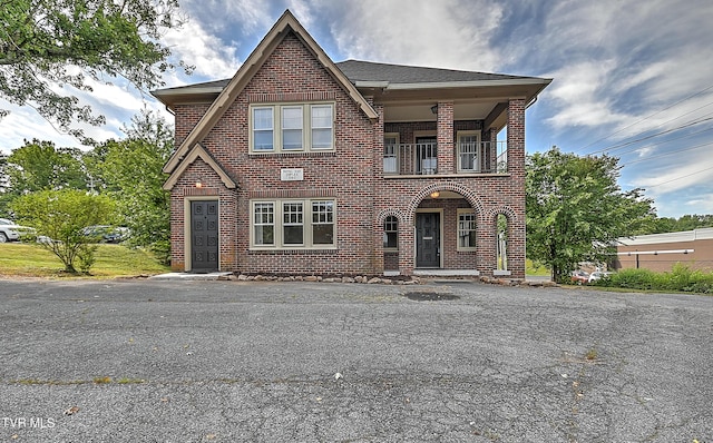 view of front of property featuring brick siding and a balcony