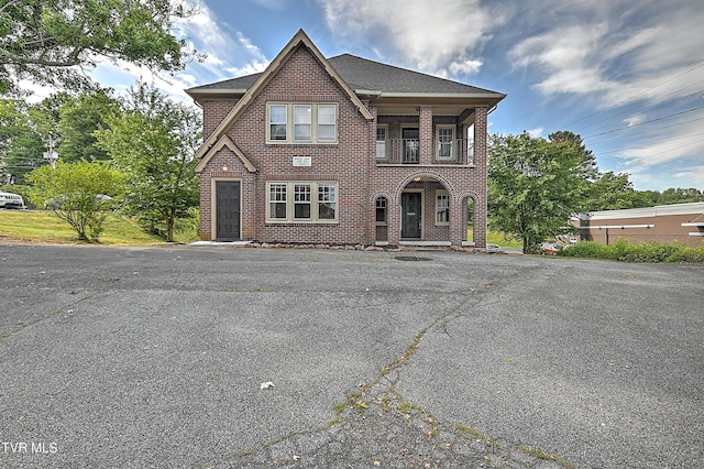view of front facade featuring a shingled roof and brick siding