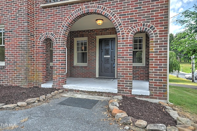 view of exterior entry featuring brick siding