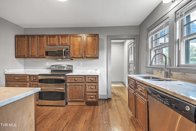 kitchen with dark wood-style flooring, light countertops, appliances with stainless steel finishes, and a sink