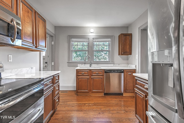 kitchen featuring light countertops, stainless steel appliances, dark wood-type flooring, and a sink