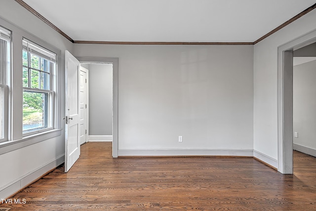 spare room with crown molding, baseboards, and wood finished floors