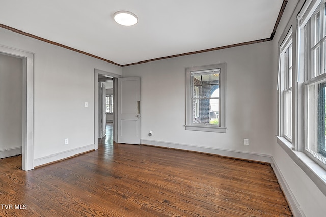 unfurnished room with crown molding, dark wood-type flooring, and baseboards