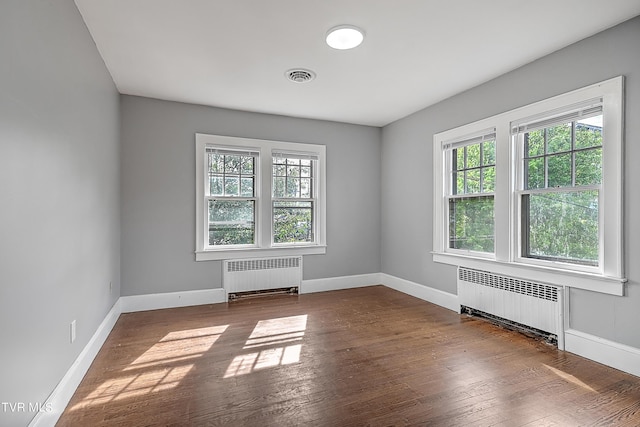 spare room with baseboards, visible vents, and radiator heating unit