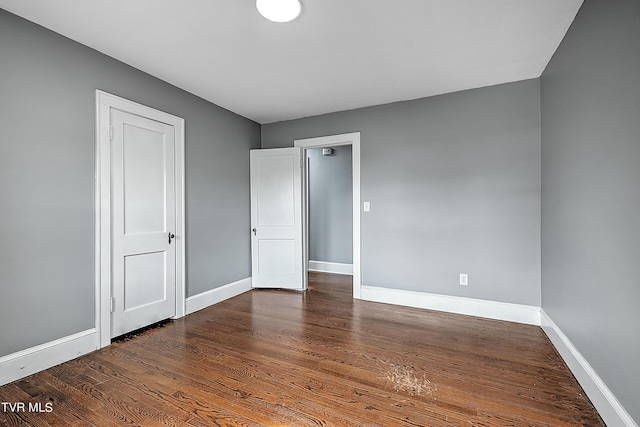 unfurnished bedroom with baseboards and wood finished floors