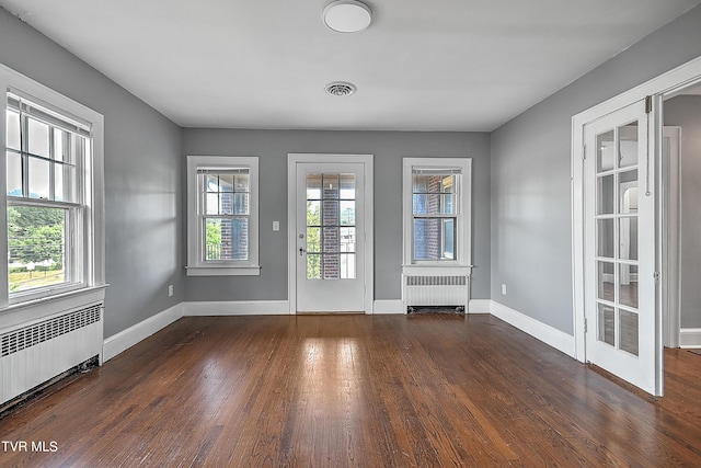 interior space featuring baseboards, radiator, and wood finished floors