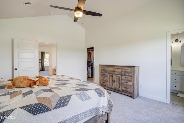 bedroom featuring a spacious closet, high vaulted ceiling, connected bathroom, a closet, and light carpet