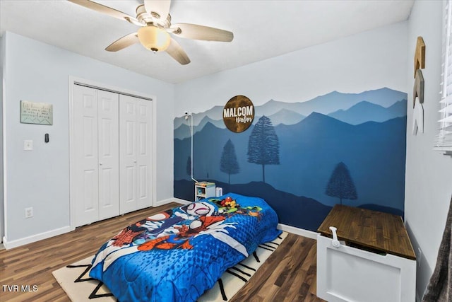 bedroom featuring baseboards, a closet, ceiling fan, and wood finished floors