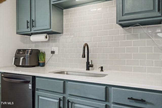 kitchen with a sink, light countertops, decorative backsplash, and dishwashing machine