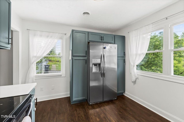 kitchen with stainless steel refrigerator with ice dispenser, visible vents, dark wood finished floors, black range with electric cooktop, and baseboards