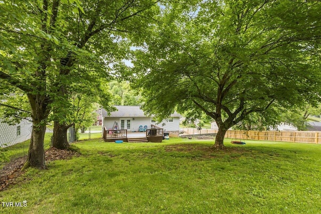 view of yard with a fenced backyard, a wooden deck, and french doors