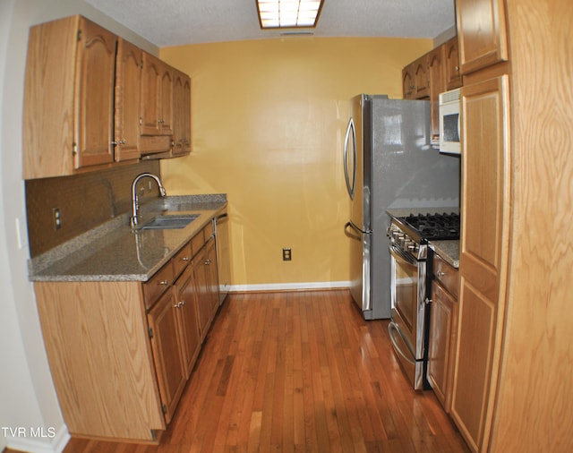 2700 Indian Ridge Rd Unit 23, Johnson City, TN 37604 - kitchen with stainless steel appliances, a sink, dark wood-style floors, baseboards, and brown cabinets