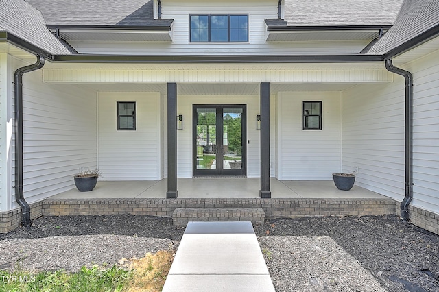 property entrance featuring a porch, a shingled roof, and french doors