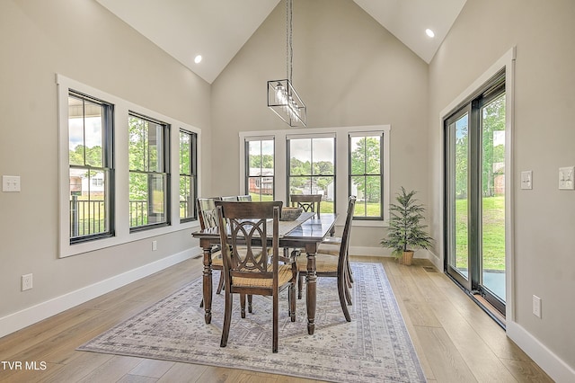 dining space featuring baseboards, recessed lighting, light wood-style flooring, and high vaulted ceiling