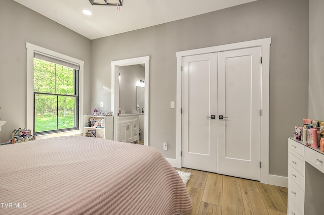bedroom featuring a closet, recessed lighting, baseboards, light wood finished floors, and connected bathroom