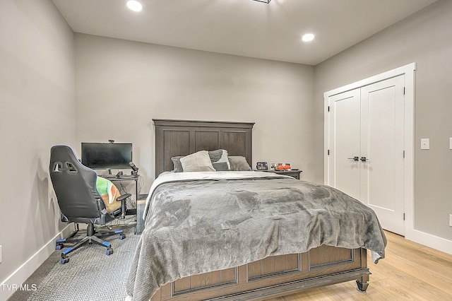 bedroom featuring baseboards, light wood-type flooring, and recessed lighting