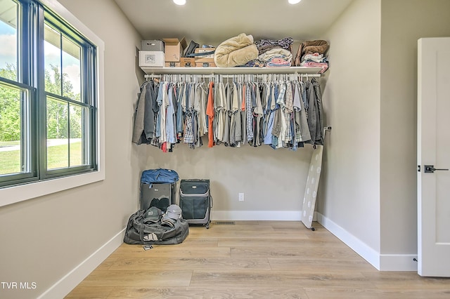 walk in closet with wood finished floors