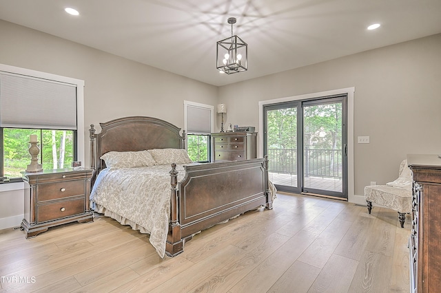 bedroom featuring light wood finished floors, multiple windows, access to outside, and baseboards