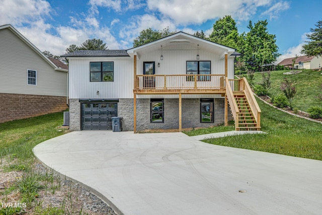 view of front of home featuring stone siding, a garage, a front lawn, driveway, and stairs
