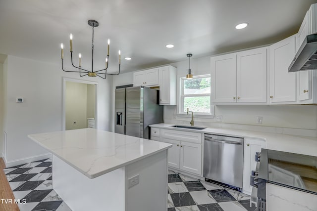 kitchen featuring a sink, stainless steel appliances, white cabinetry, and a center island
