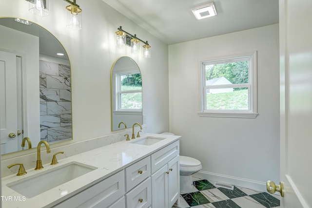 bathroom with a wealth of natural light, marble finish floor, and a sink