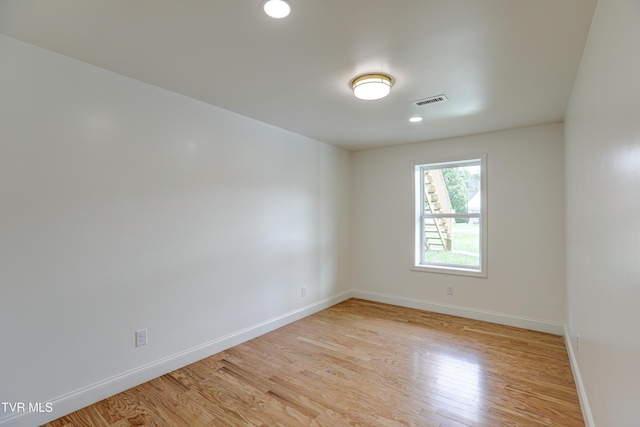 empty room with baseboards, light wood-type flooring, visible vents, and recessed lighting
