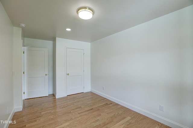 unfurnished bedroom featuring baseboards, light wood-type flooring, a closet, and recessed lighting