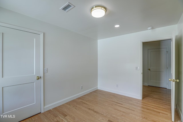 spare room featuring light wood finished floors, baseboards, visible vents, and recessed lighting