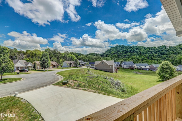 view of yard with concrete driveway and a residential view