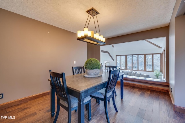 dining area with baseboards, a chandelier, a textured ceiling, and wood finished floors