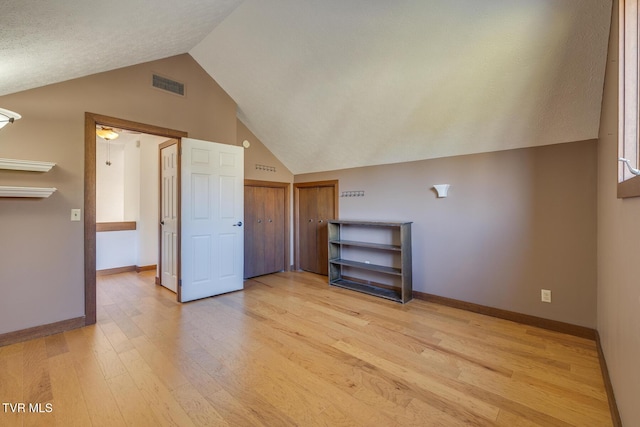 bonus room with lofted ceiling, baseboards, visible vents, and light wood-style floors