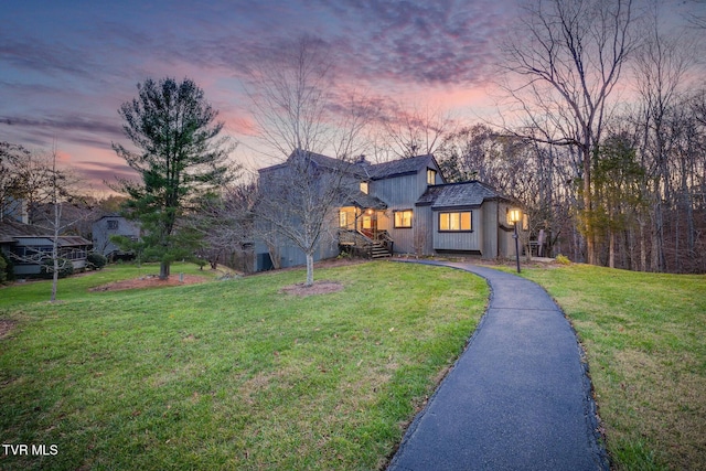 view of front of home with aphalt driveway and a front lawn