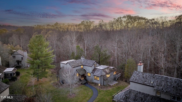 aerial view at dusk with a wooded view