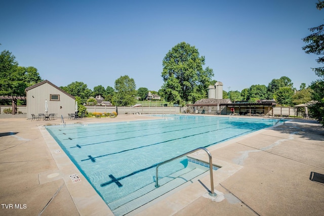community pool with fence and a patio area