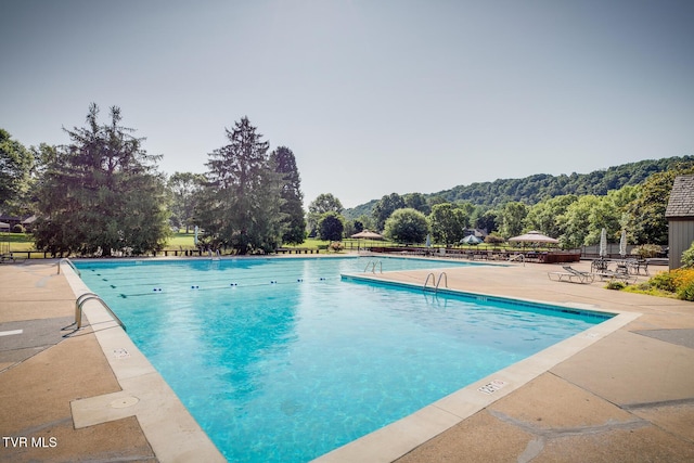 community pool with a patio and fence