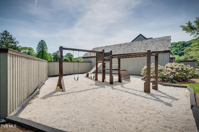 community jungle gym featuring a fenced backyard