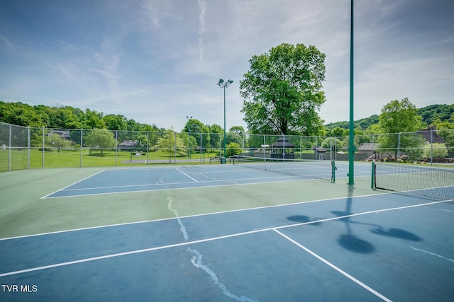 view of tennis court with fence and community basketball court